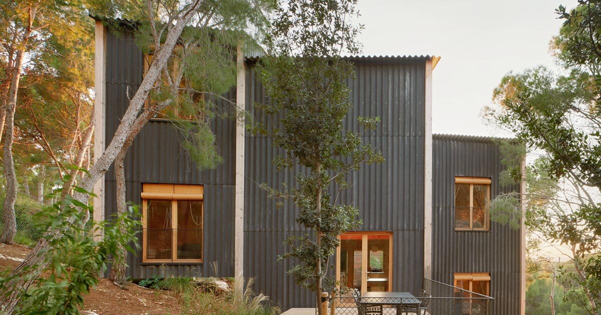 timber house in spain interlaces three raised volumes within tree canopy