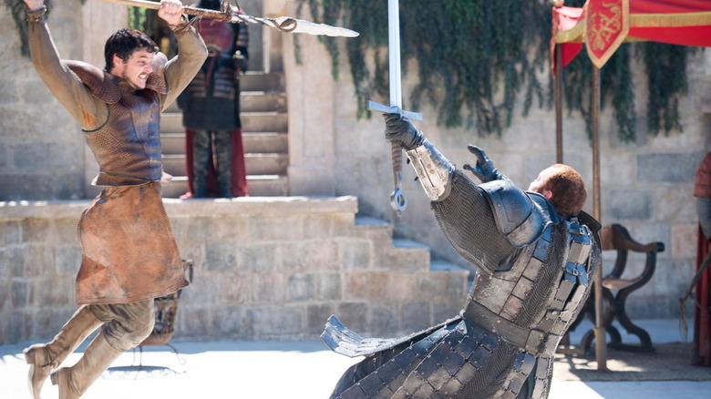 Pedro Pascal as Oberyn Martell holding up a spear and attacking Hafþór Júlíus Björnsson as Gregor Clegane in Game of Thrones