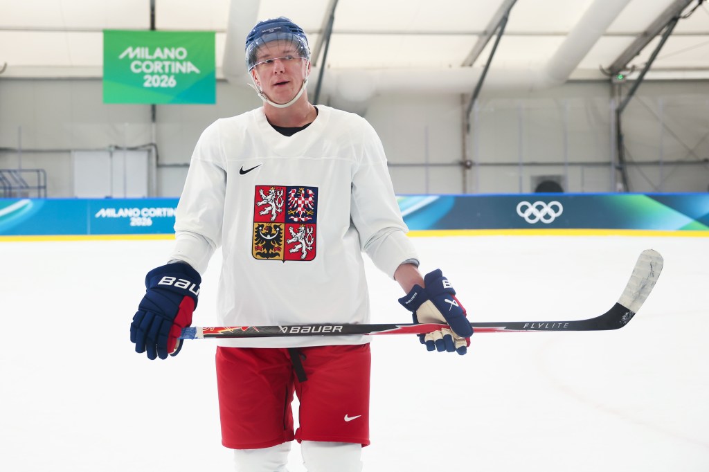 Ondrej Palat, wearing a Czechia jersey, stands on the ice holding a hockey stick.