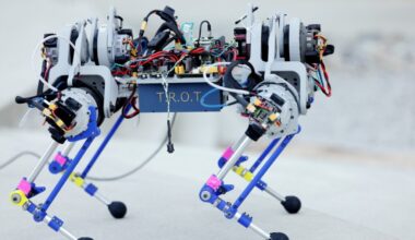 The robot has four legs with backward-facing knees. Each leg has three actuators, controlling hip ab/adduction, hip flexion/extension, and knee flexion/extension.  Exposed wires link up to the motors. T.R.O.T is emblazoned on the case around the belly of the robot.