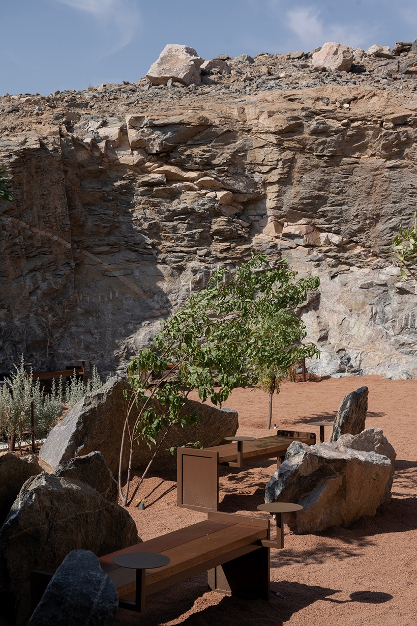 open planted courtyard organizes a café carved directly into rock in saudi arabia