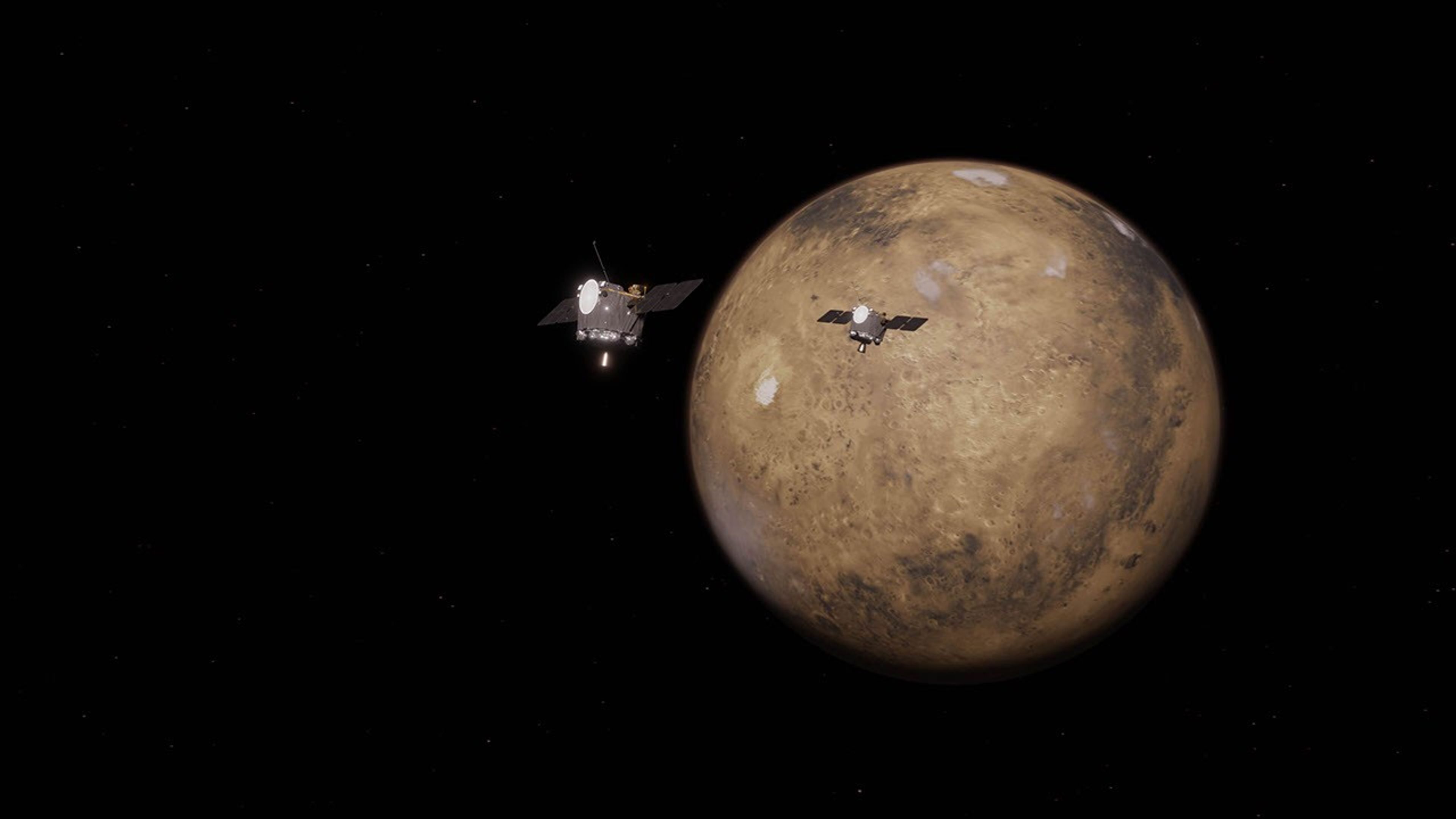 An animation showing Mars against a black background. Two spacecraft � like short gray cyclinders with flat panels on the right and left � orbit the planet.