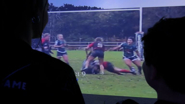 Researchers watch footage of a collision during a women's rugby match