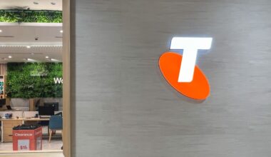 A close up of the Telstra logo on the side of a Telstra store wall.