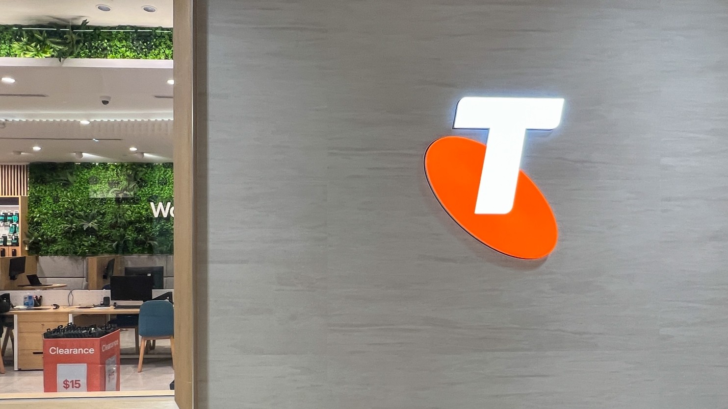 A close up of the Telstra logo on the side of a Telstra store wall.