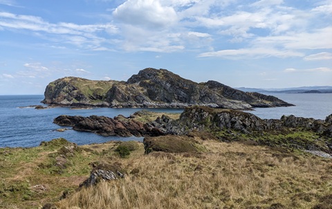 Rocky islands covered in grass, under a blue sky