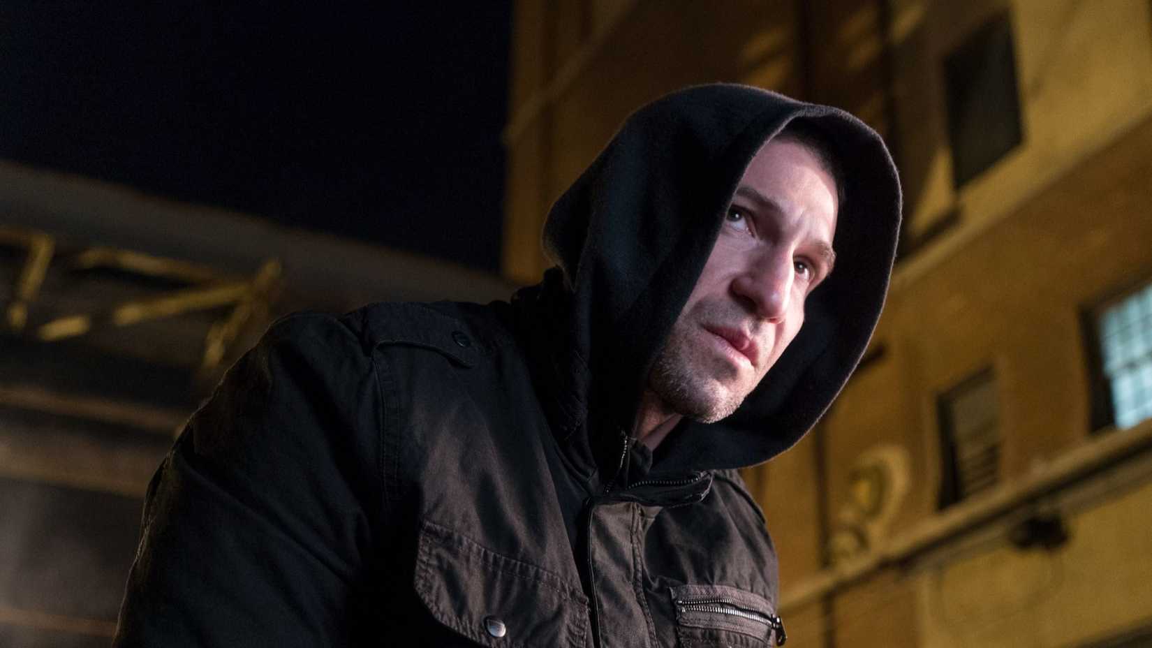 Frank Castle (Jon Bernthal) looking out from under his hoodie in The Punisher.