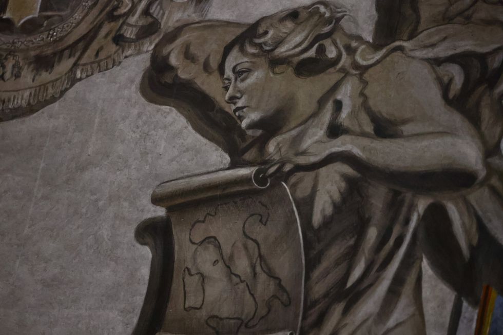 \u200bA restored angel fresco is displayed inside the Basilica of St. Lawrence in Lucina