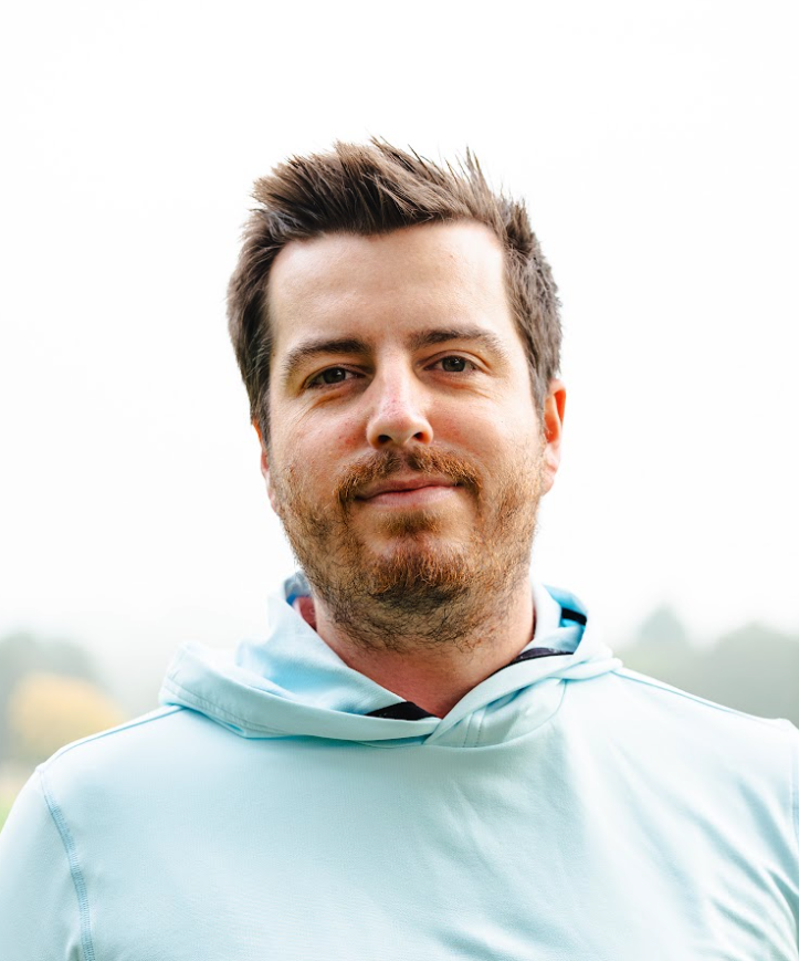 A headshot of Elliott Heath from the chest up wearing a sky blue hoodie