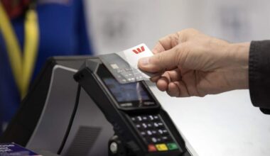 A hand tapping a credit card on a machine.