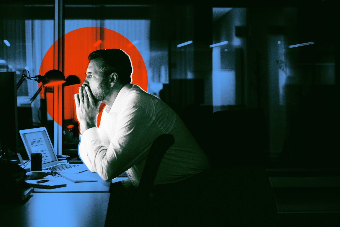 A man in a white shirt sits at a desk in a dimly lit office, leaning forward with his hands clasped near his face in a thoughtful pose. A laptop, a desk lamp, and various papers and objects are on the desk. A large red circle is digitally overlaid behind the man, contrasting with the dark and blue-toned background.