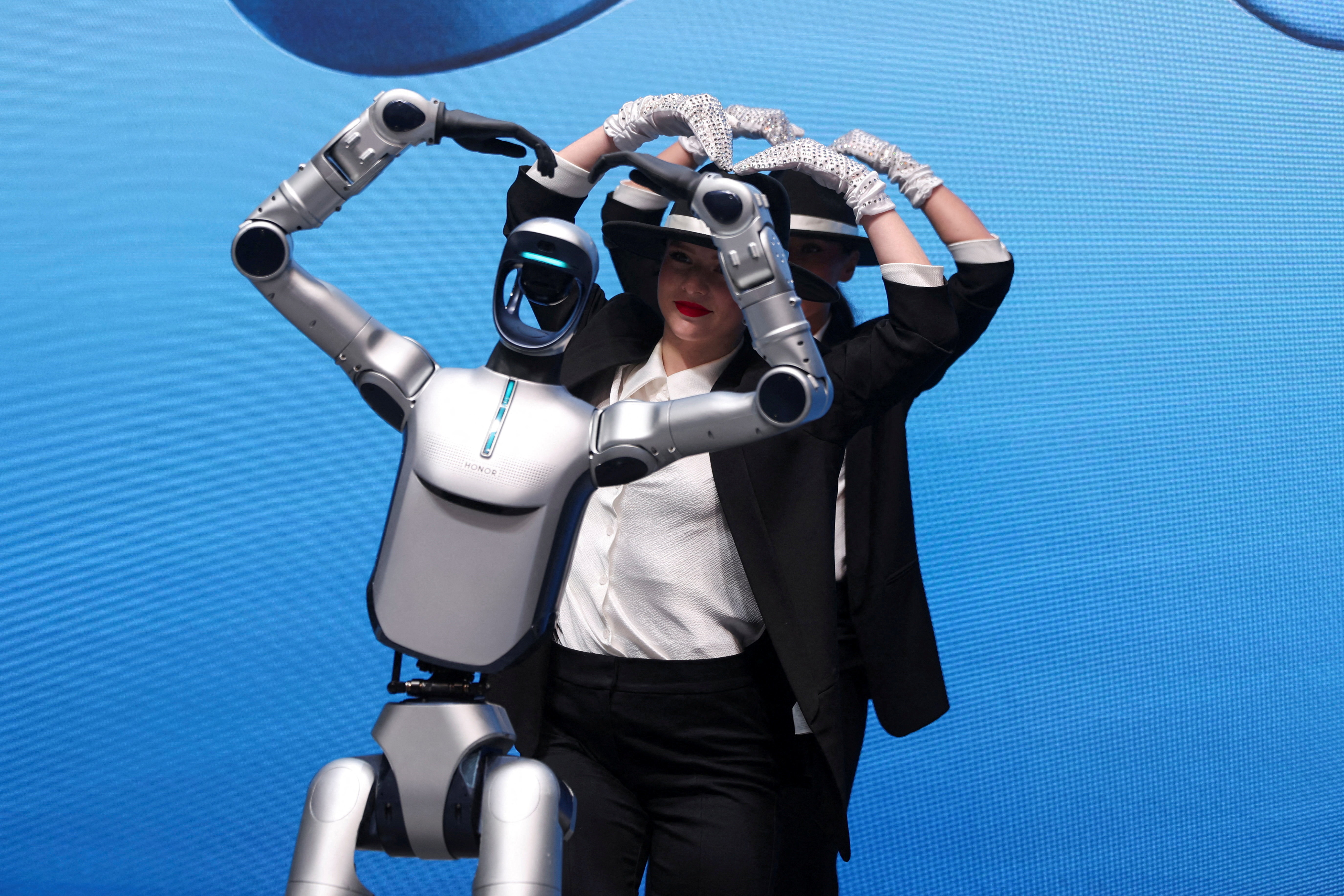 An Honor prototype robot dances alongside performers at the Mobile World Congress trade show.