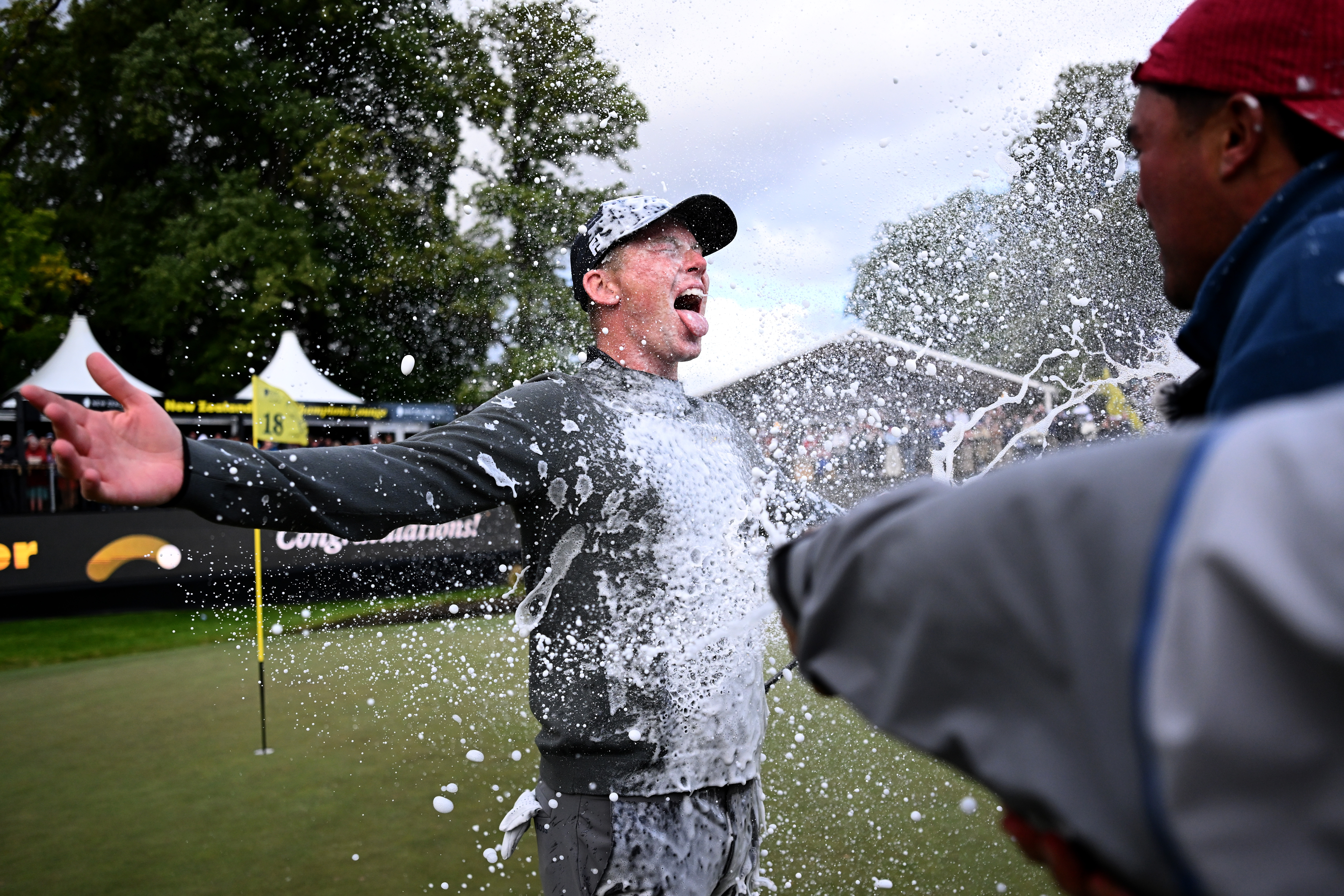 Daniel Hillier of New Zealand being sprayed with champagne after winning the New Zealand Open.