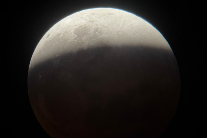 A white moon in a dark sky