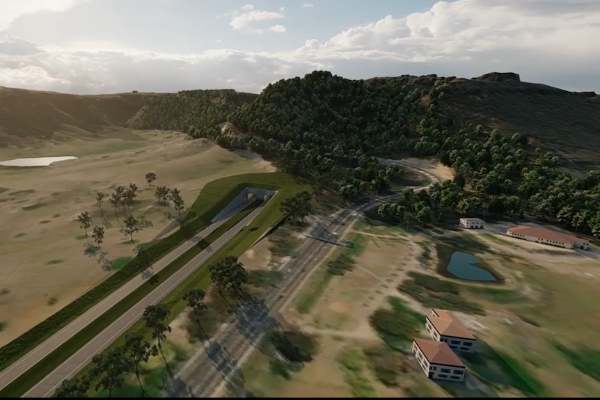 Aerial image of a road in country side, leading to a tunnel under a hill.