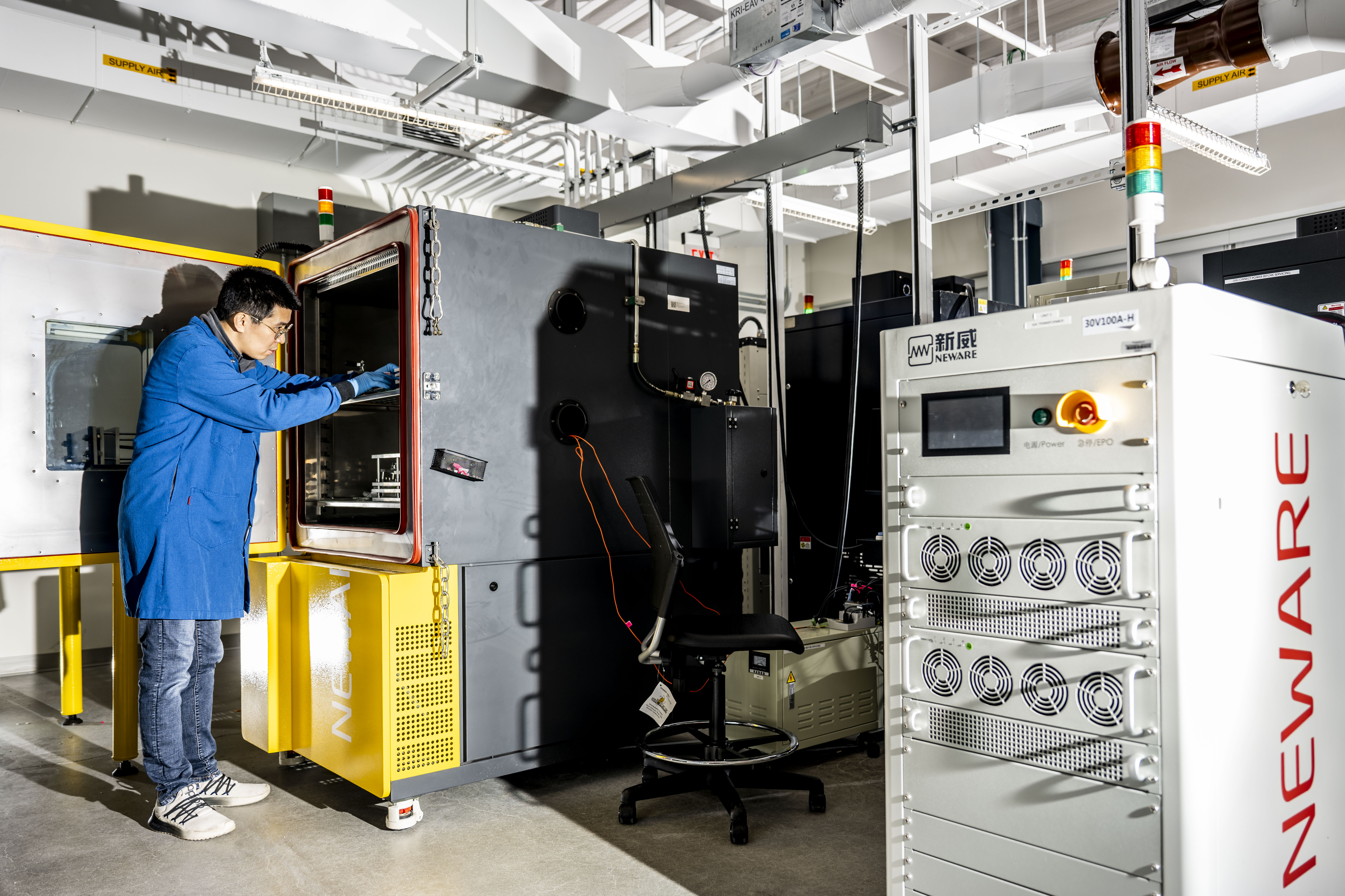 A researcher stands inside a large, high-tech lab with industrial equipment at the Kostas Research Institute.