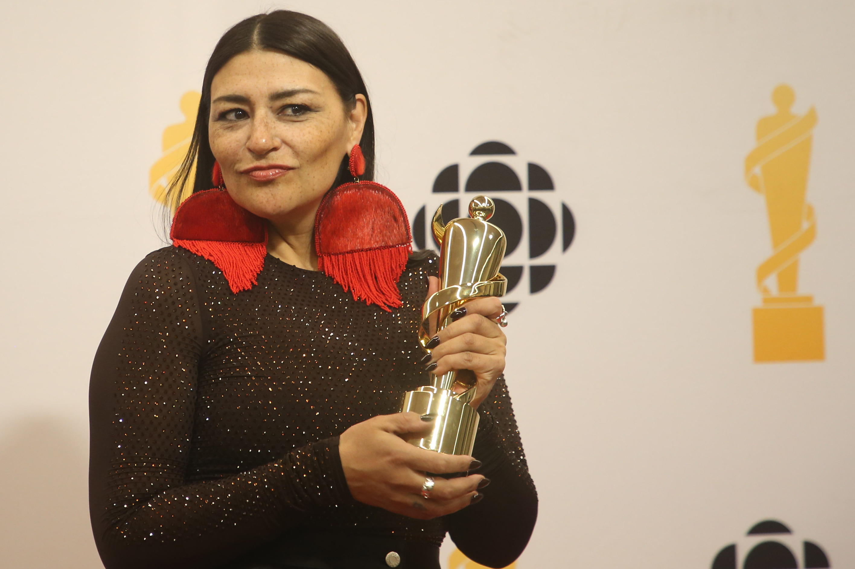 Quebec musician Elisapie holds her Juno Award with both hands.