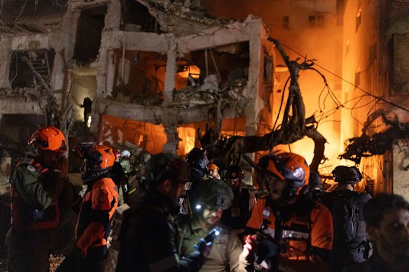 Rescue forces operate at a building hit by an Iranian missile strike in Tel Aviv.