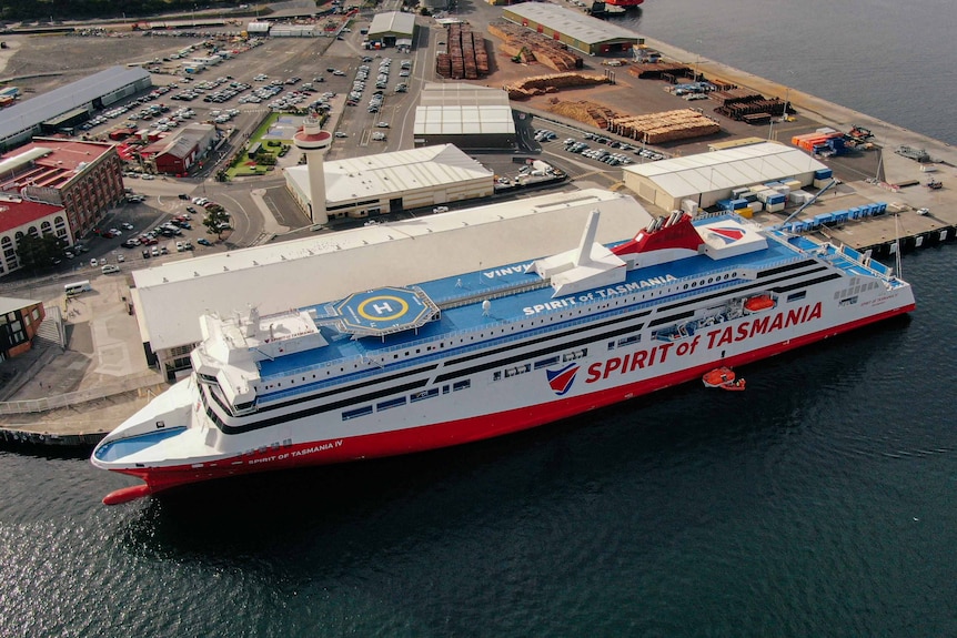 Big red ship docked in water