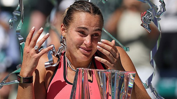 Aryna Sabalenka poses with the championship trophy after defeating Elena Rybakina.