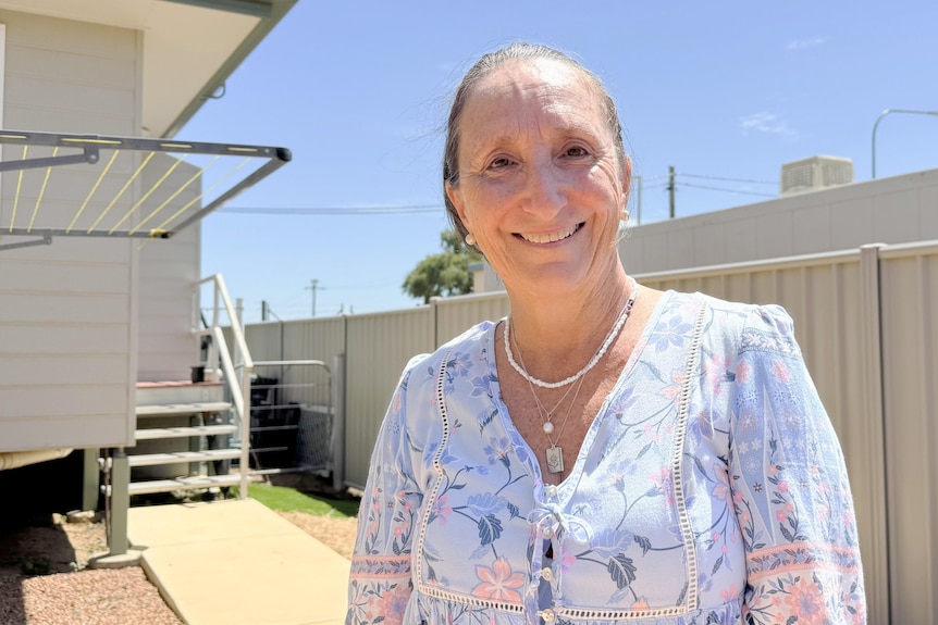 Woman smiles in backyard of home