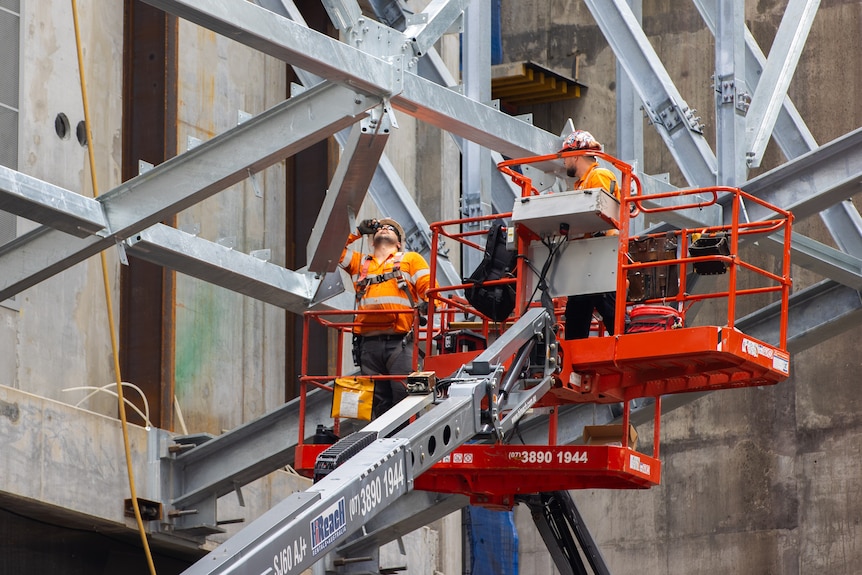 Construction workers in high visibility clothing working on a construction site.