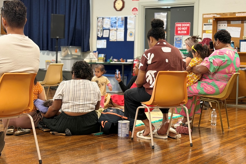 a group of migrant workers sitting down on chairs in a hall during a workshop about migrant worker exploitation