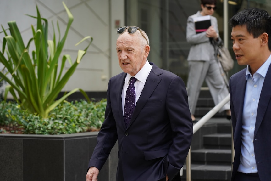 A man in a suit walks down the stairs of a court building in Perth 