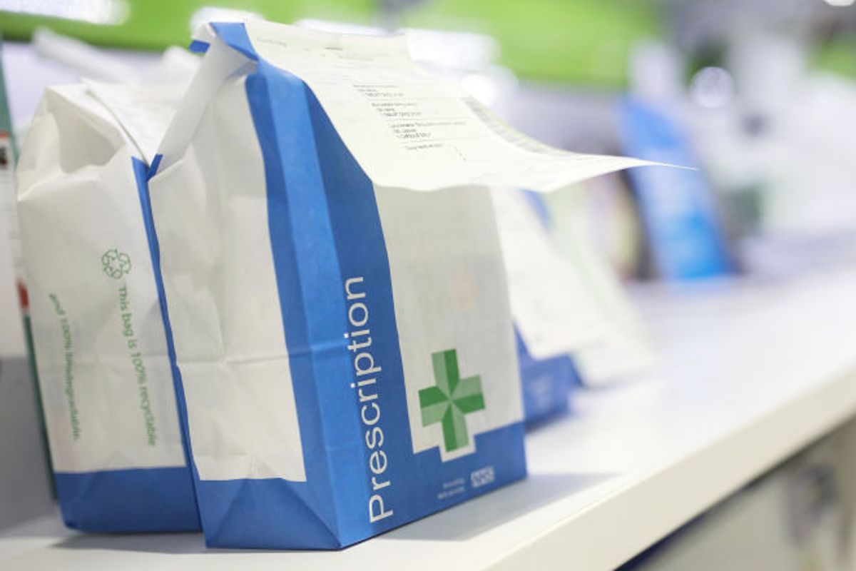 Bags of completed medical prescriptions sit on the counter and await collection by customers from Hodgson Pharmacy 
