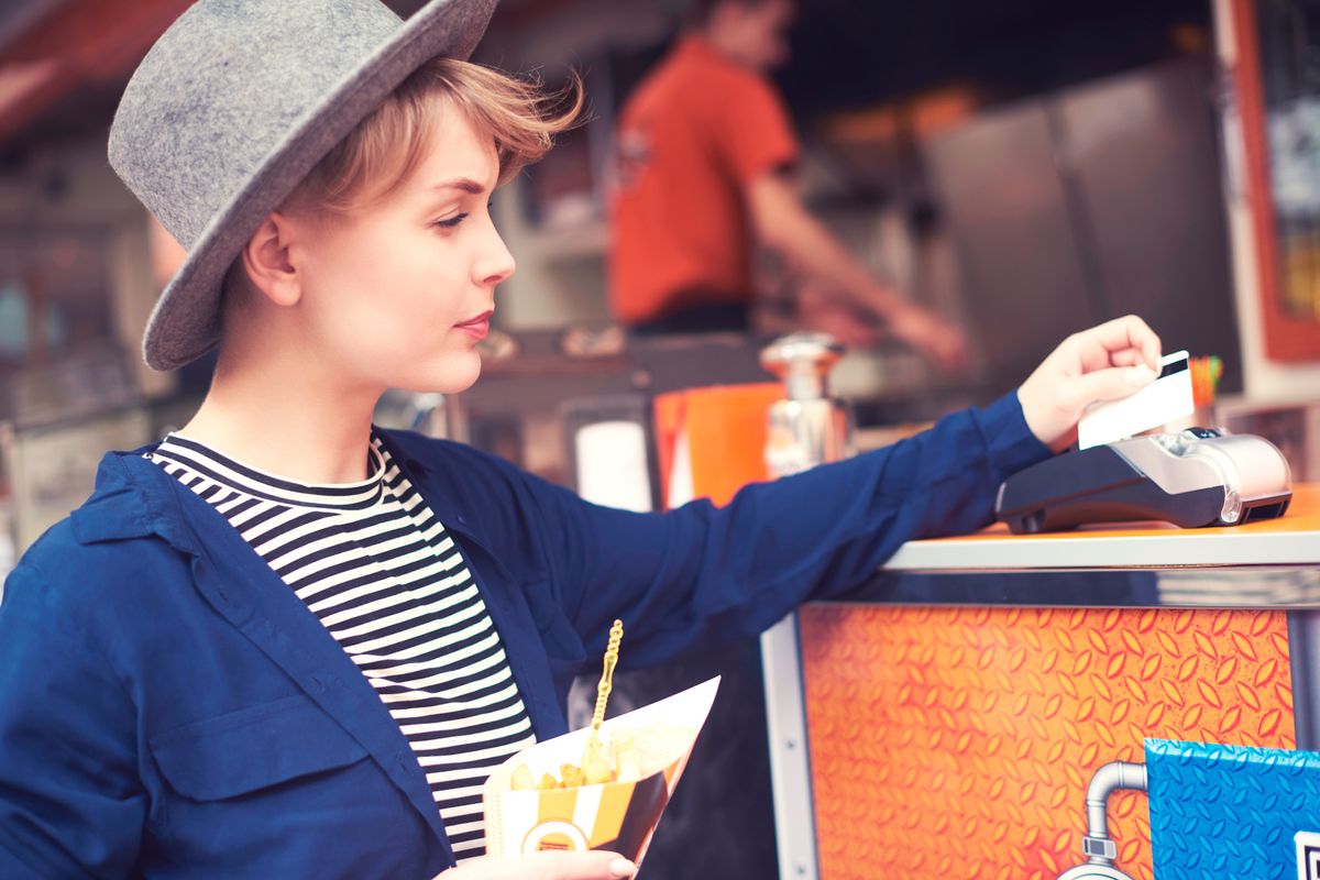 woman pays bill with contactless card