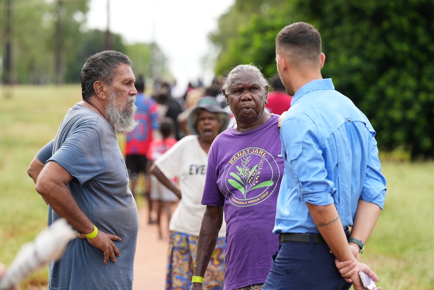 A man and a woman speak with a government staffer
