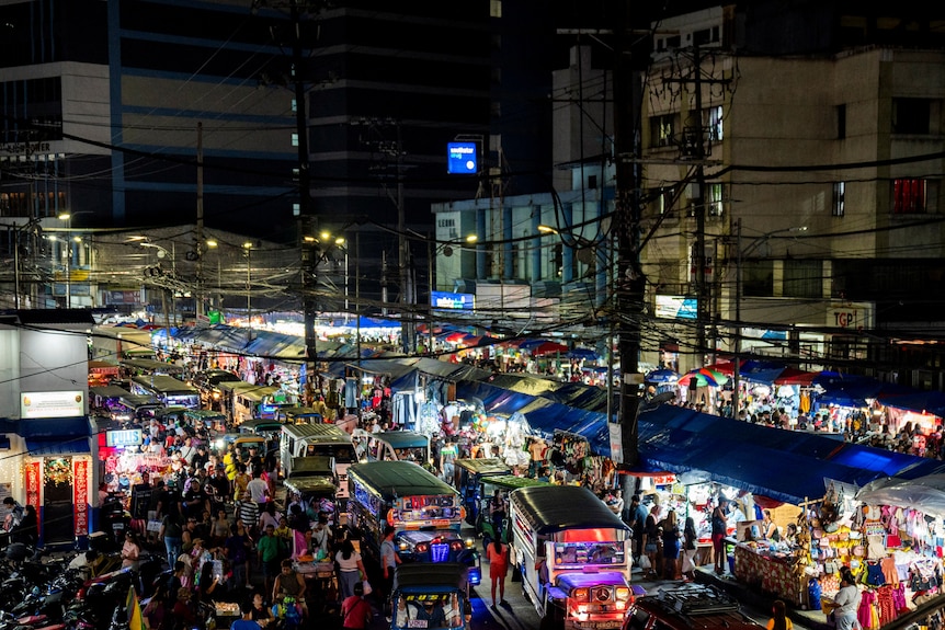 Cars and tuktuks on a street.