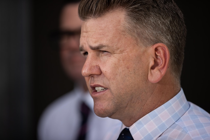 Close up profile photo of a man in a button shirt