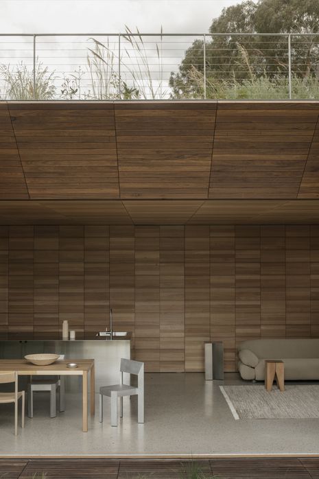 Integrated cabinetry and a reflective island bench prevent the kitchen from dominating the living space.