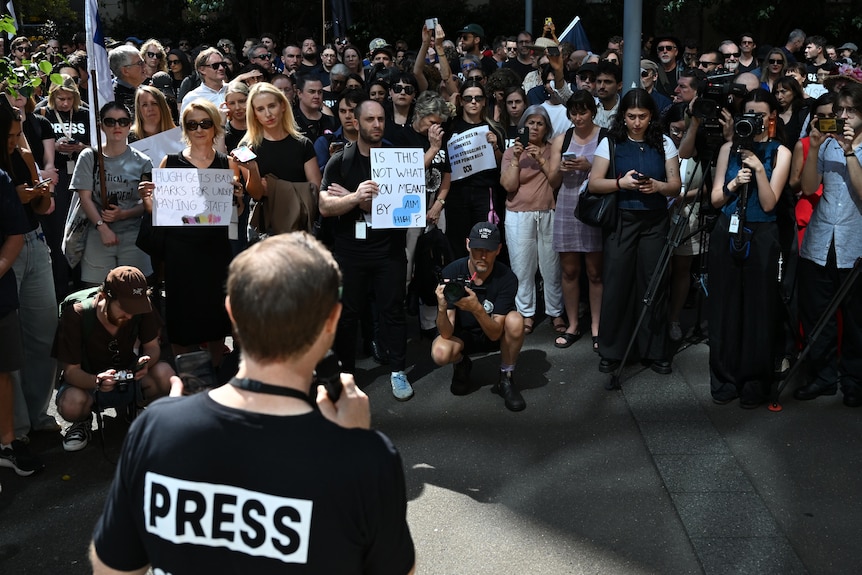 Dozens of people gathered wearing black