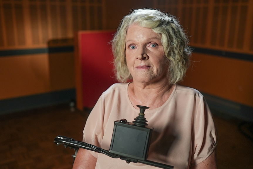 A middle-aged white woman sitting in a wheelchair.