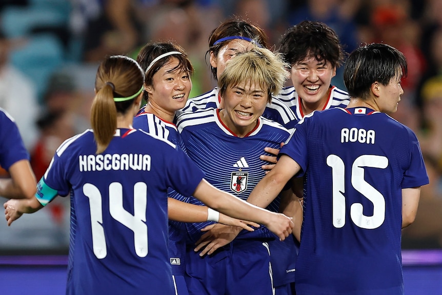 Japan women's footballers celebrate a goal