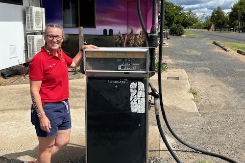A woman stands next to a diesel bowser at a fuel station in regional Australia.