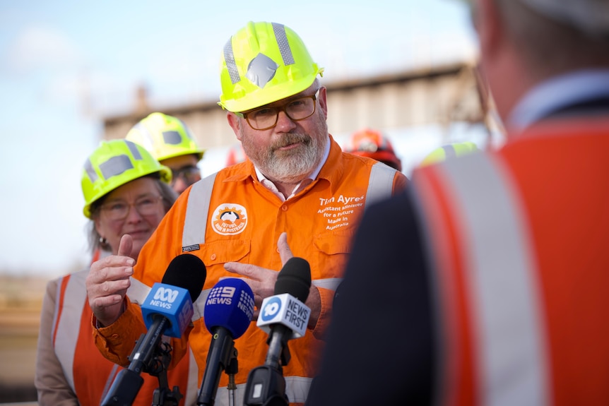 People in hardhats at a steelworks.