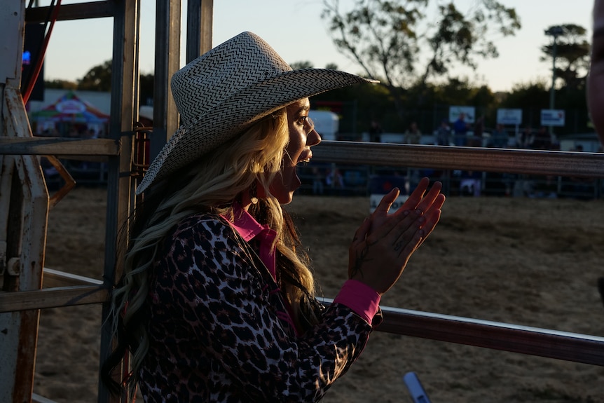 A woman cheering at a rodeo gate