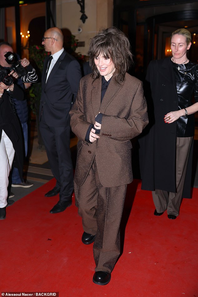 Winona Ryder cut a smart figure in a brown suit as she graced the red carpet for photos