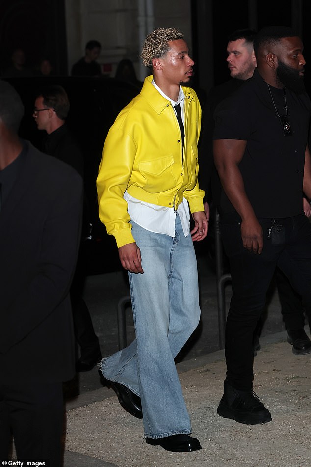 French footballer Hugo Ekitike cut a trendy figure at the show, wearing a vibrant yellow leather jacket paired with wide-leg blue denim jeans