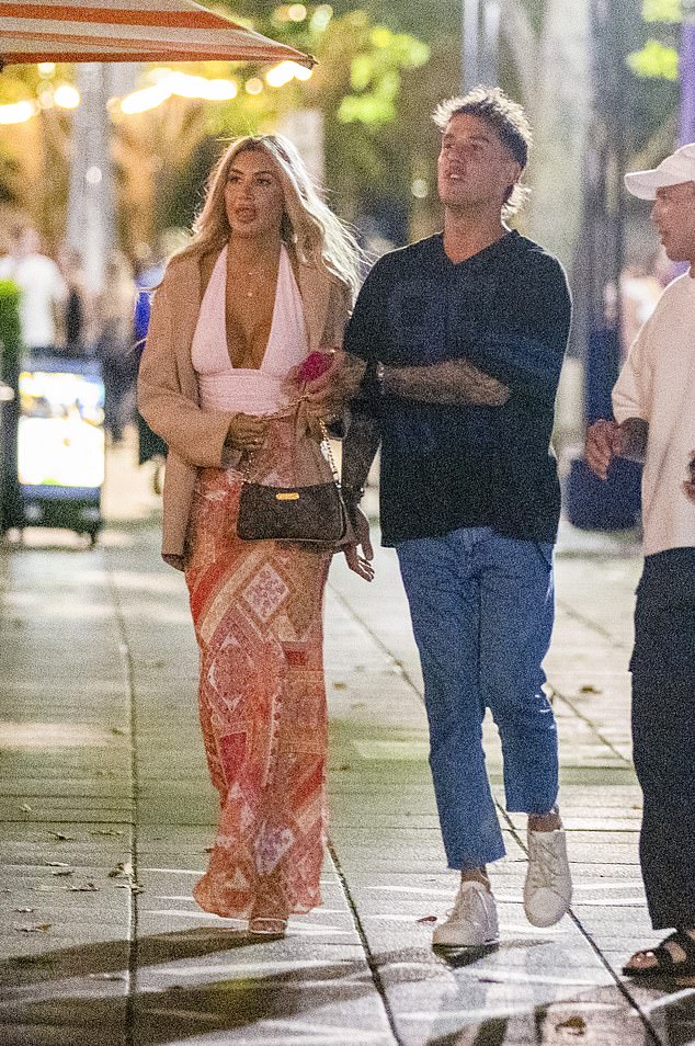 Dressed for a fun night out, Gia turned heads in a plunging white halter-style top paired with a flowing orange patterned maxi skirt that skimmed the pavement