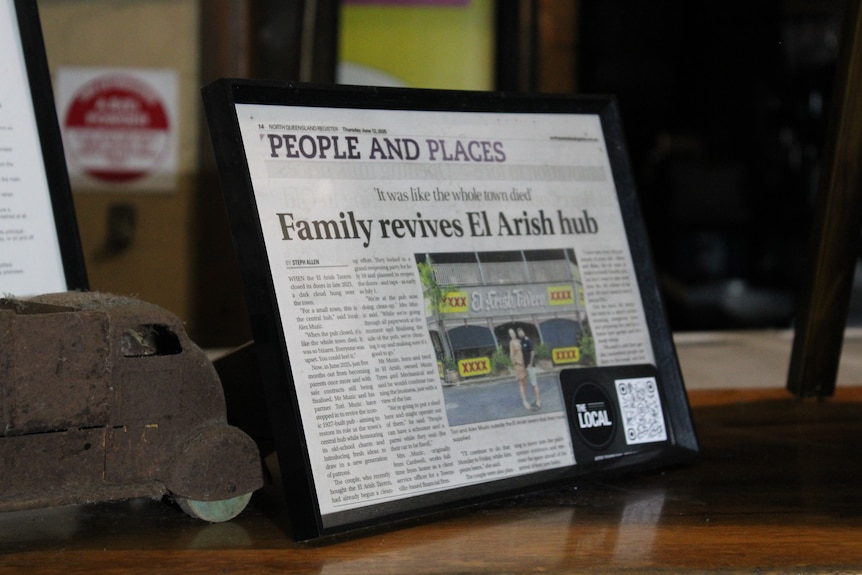 Two tourists posing for a selfie in front of a whole smoked crocodile.