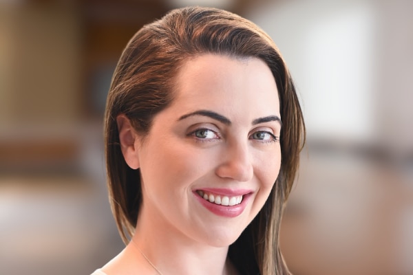 A woman in a white top smiling at the camera