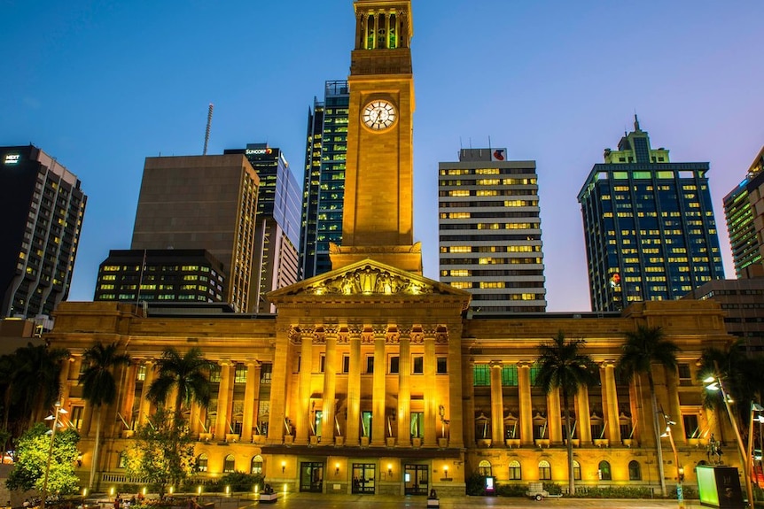 Brisbane City Hall at dusk lit with yellow lights. 