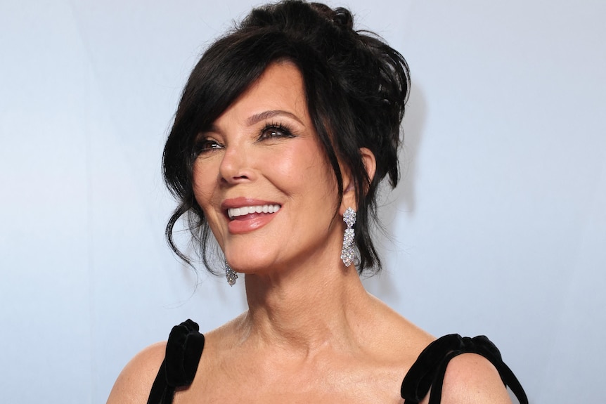 A woman looks at the camera smiling.