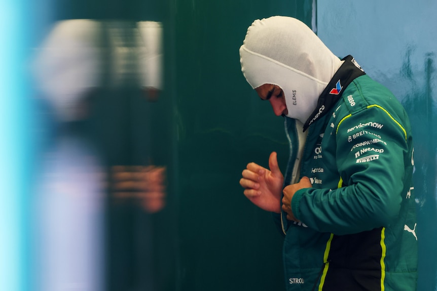 Lance Stroll of Aston Martin putting on his race suit