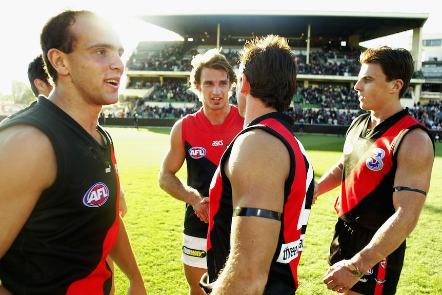Chris Heffernan shakes hands with old Essendon teammates