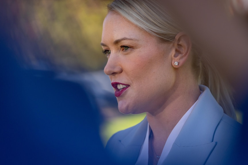 Side profile of Ashton Hurn speaking to media in a park